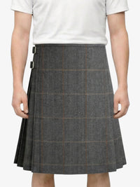 Person wearing a gray checkered skirt on a white background
