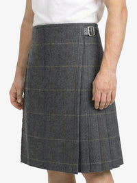 Person wearing a gray checkered skirt on a white background