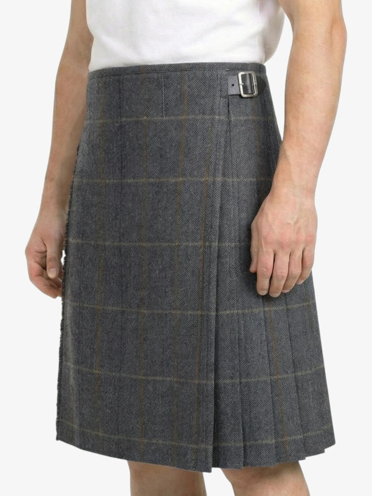 Person wearing a gray checkered skirt on a white background