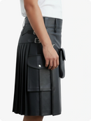 Black pleated skirt with silver buckles worn by a person on a white background