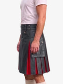 A man wearing a black faux-leather kilt with red pleated lining, paired with a light pink t-shirt and cream socks, shown from the waist down against a plain white background.