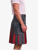 A side view of a person wearing a black leather kilt with red pleated lining and silver metal hardware, paired with a light pink t-shirt and white socks, against a plain white background.