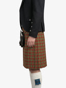Person wearing a black jacket and red plaid kilt on a white background
