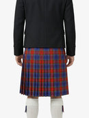 Person wearing a black jacket and red, blue, and green plaid kilt on a white background