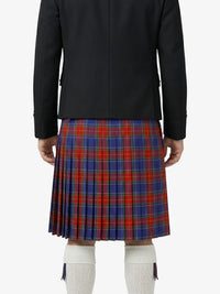 Person wearing a black jacket and red, blue, and green plaid kilt on a white background