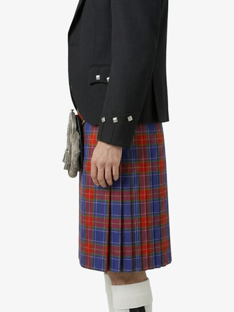 Person wearing a black blazer and red, blue, and white plaid kilt on a white background