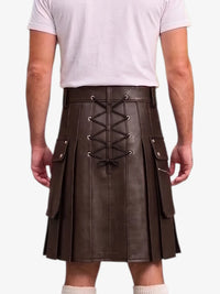 A man wearing a dark brown faux-leather kilt with a lace-up front, side pockets, and pleated detailing, paired with a light pink t-shirt and white socks.
