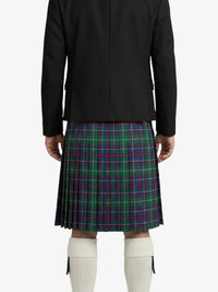 Person wearing a black jacket and plaid kilt on a white background