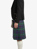 Person wearing a black blazer and tartan kilt on a white background