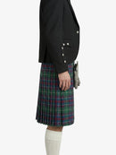 Person wearing a black blazer and plaid kilt on a white background