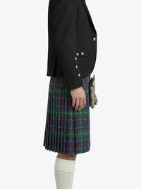 Person wearing a black blazer and plaid kilt on a white background