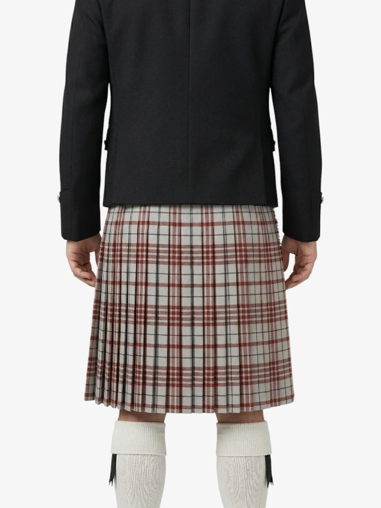 Person wearing a black jacket and plaid kilt on a white background