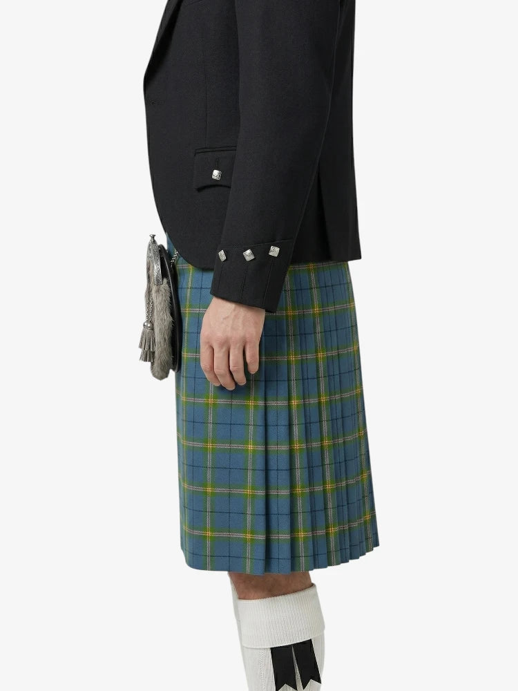 Person wearing a black jacket and blue plaid kilt on a white background