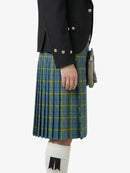 Person wearing a black jacket and blue plaid kilt on a white background