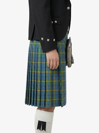 Person wearing a black jacket and blue plaid kilt on a white background