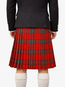 Person wearing a red plaid kilt with a black jacket on a white background