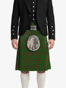 Person wearing a green tartan kilt with a black jacket on a white background