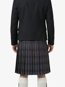 Person wearing a black jacket and plaid kilt on a white background