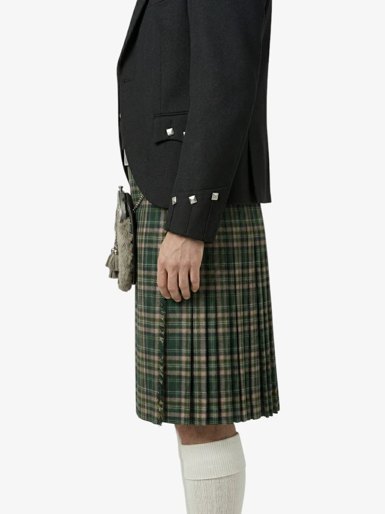 Person wearing a black jacket and green plaid kilt on a white background