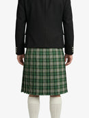 Person wearing a black jacket and green plaid kilt on a white background