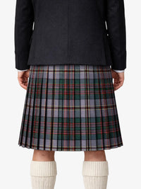 Person wearing a black jacket and plaid kilt on a white background