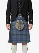 Person wearing a traditional Scottish kilt with a jacket and white knee-high socks on a white background