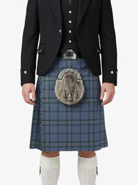 Person wearing a traditional Scottish kilt with a jacket and white knee-high socks on a white background
