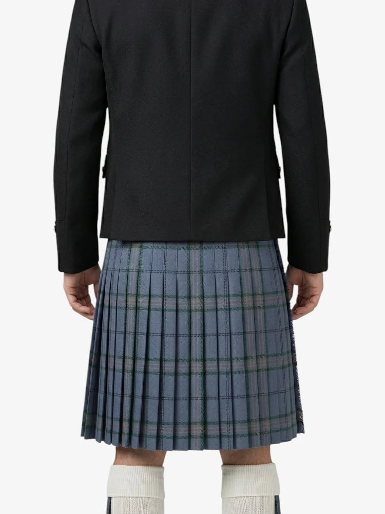 Person wearing a black jacket and blue plaid kilt on a white background