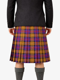 Person wearing a black jacket and a plaid kilt on a white background