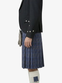 Person wearing a dark blazer and blue plaid kilt on a white background