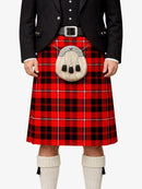 Person wearing a red tartan kilt with a black jacket and white socks on a white background