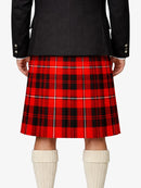 Red plaid kilt worn with a black jacket and white knee-high socks on a white background