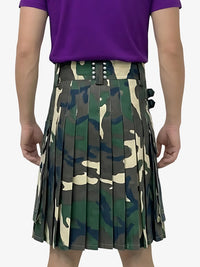 Person wearing a camouflage kilt with a purple shirt on a white background