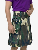 Person wearing a camouflage kilt with a purple shirt on a white background
