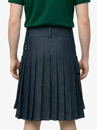Person wearing a green shirt and pleated navy skirt on a plain background