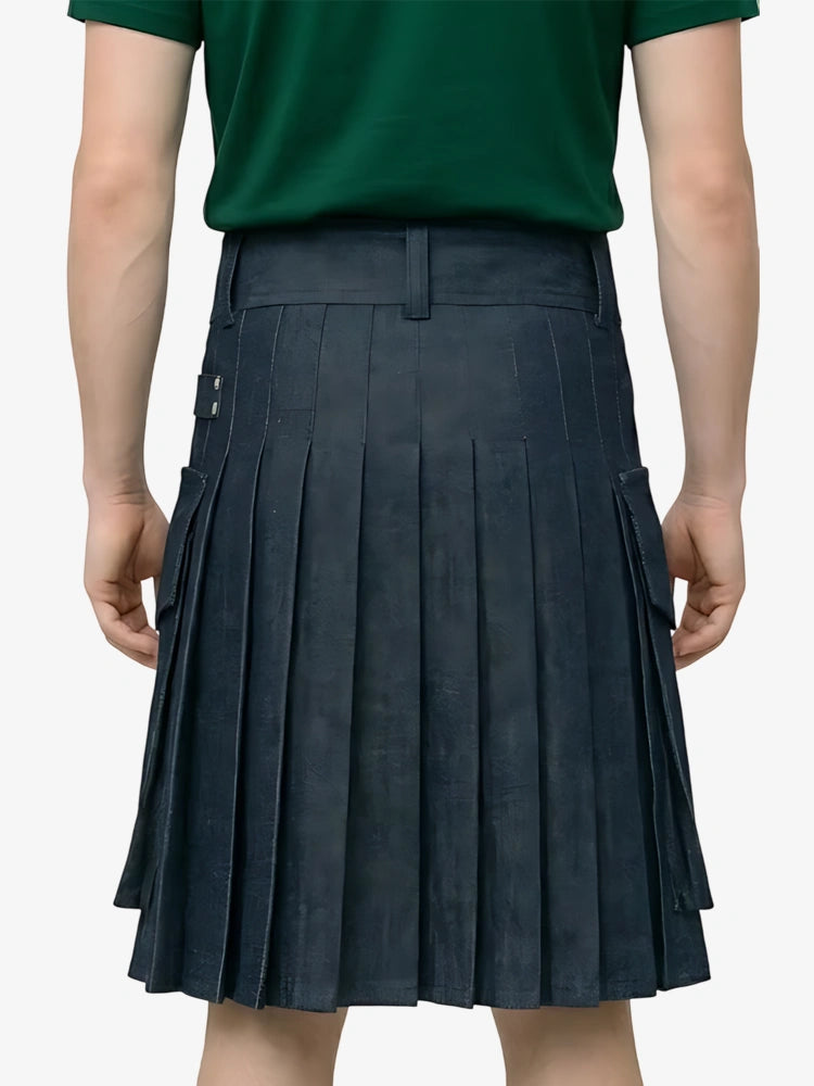 Person wearing a green shirt and pleated navy skirt on a plain background