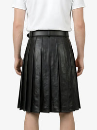 Black pleated leather skirt worn by a person on a white background