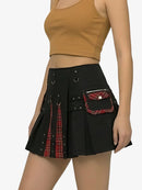 Black kilt with plaid accents worn by a person on a white background