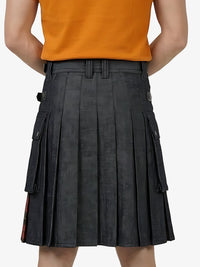 Person wearing a black pleated skirt with orange top on a white background