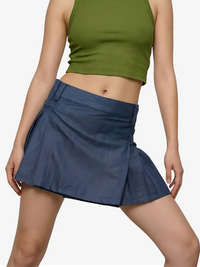 Person wearing a green crop top and blue skirt on a white background