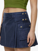 Navy blue skirt with gold buttons worn by a person on a white background