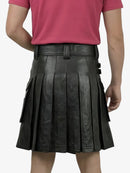 Black pleated leather skirt worn by a person on a white background