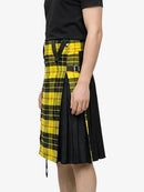 Person wearing a black and yellow plaid kilt on a white background