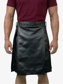 Person wearing a black leather kilt with a maroon shirt on a white background