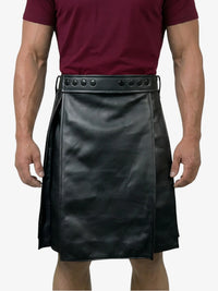 Person wearing a black leather kilt with a maroon shirt on a white background