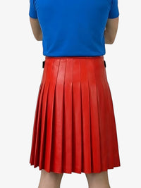 Person wearing a blue top and red pleated skirt on a white background
