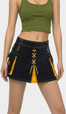 Person wearing a green crop top and black skirt with yellow accents on a white background