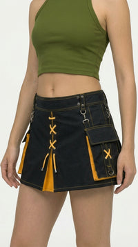 Person wearing a green crop top and black mini skirt with yellow accents on a white background