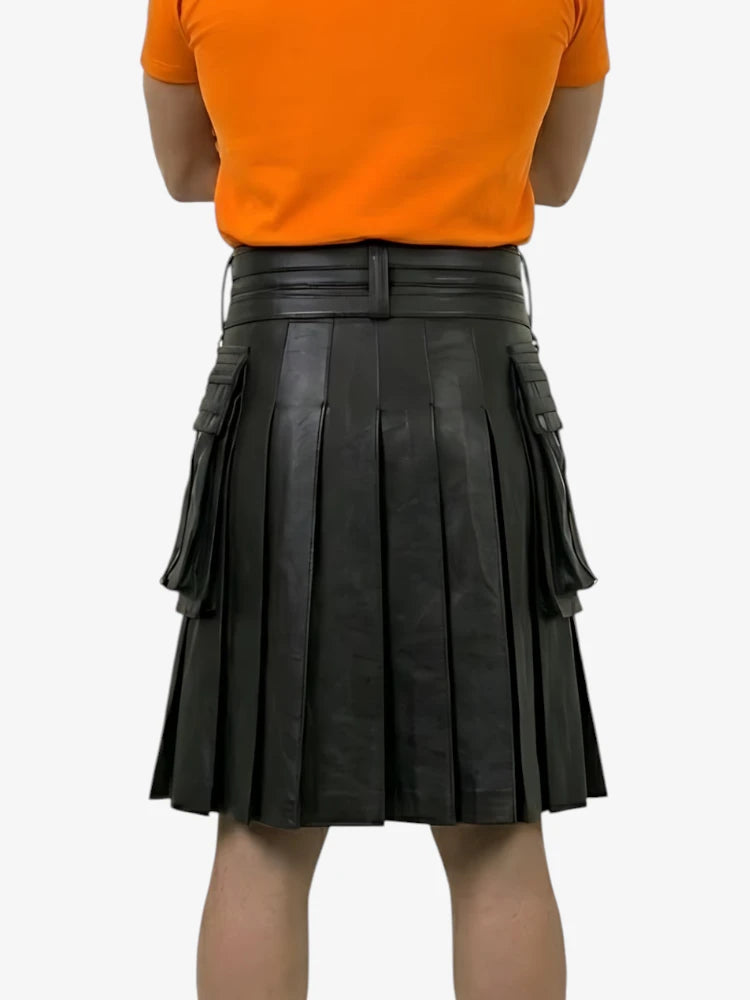 Person wearing an orange shirt and black pleated leather skirt on a white background