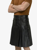 Person wearing a black leather kilt on a white background